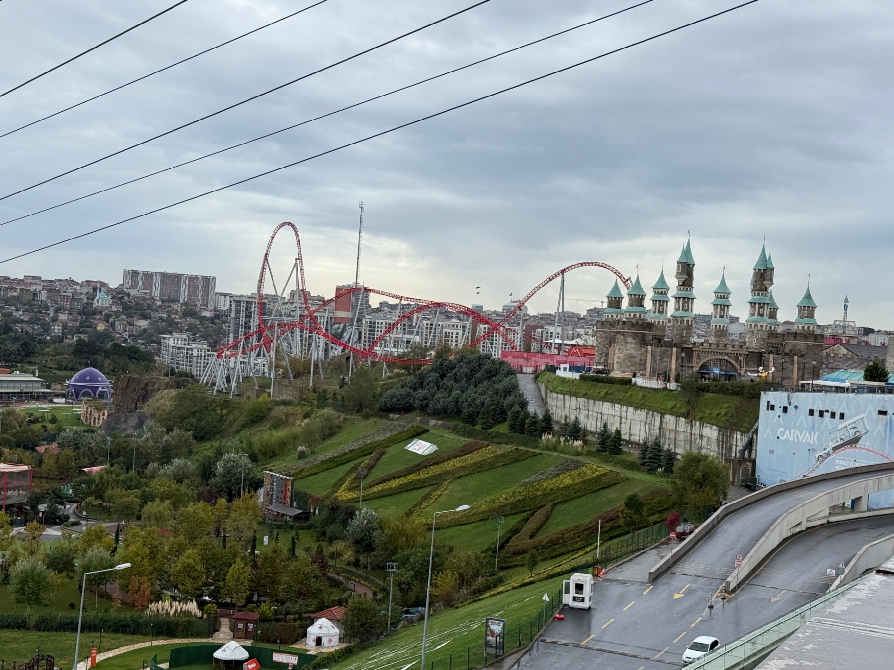 Blick über den Vialand-Freizeitpark mit roter Achterbahn und Ritterburg